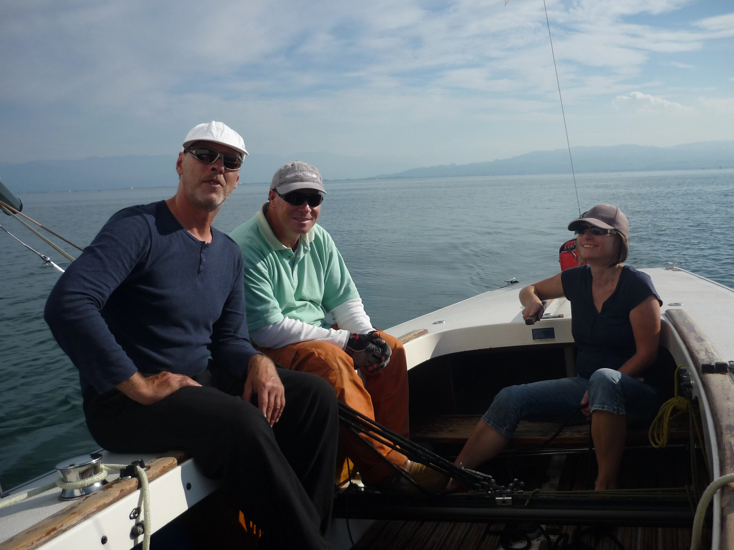 Motorboot-u. Segelschule Ravensburg - Wassersportausbildung und lizenzierung - Drei Personen mit Hüten und Sonnenbrillen sitzen zusammen auf einem fahrenden Boot.