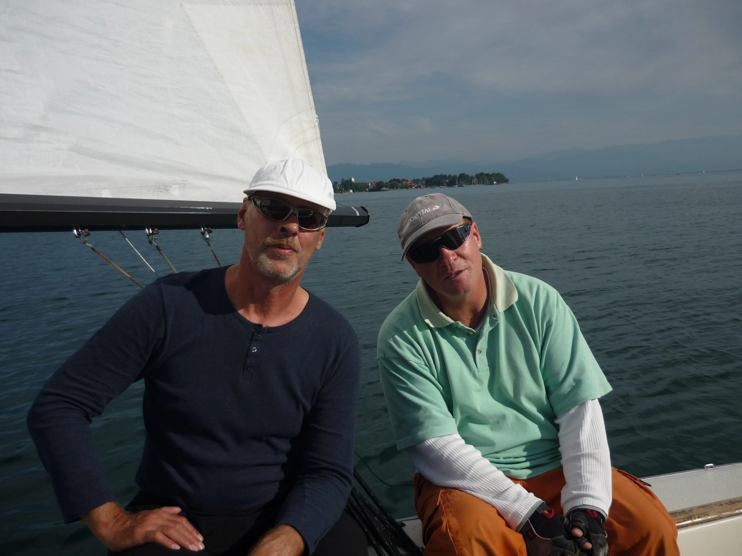 Motorboot-u. Segelschule Ravensburg - Wassersportausbildung und lizenzierung - Zwei Männer in Freizeitkleidung sitzen und entspannen sich an Deck eines Bootes.
