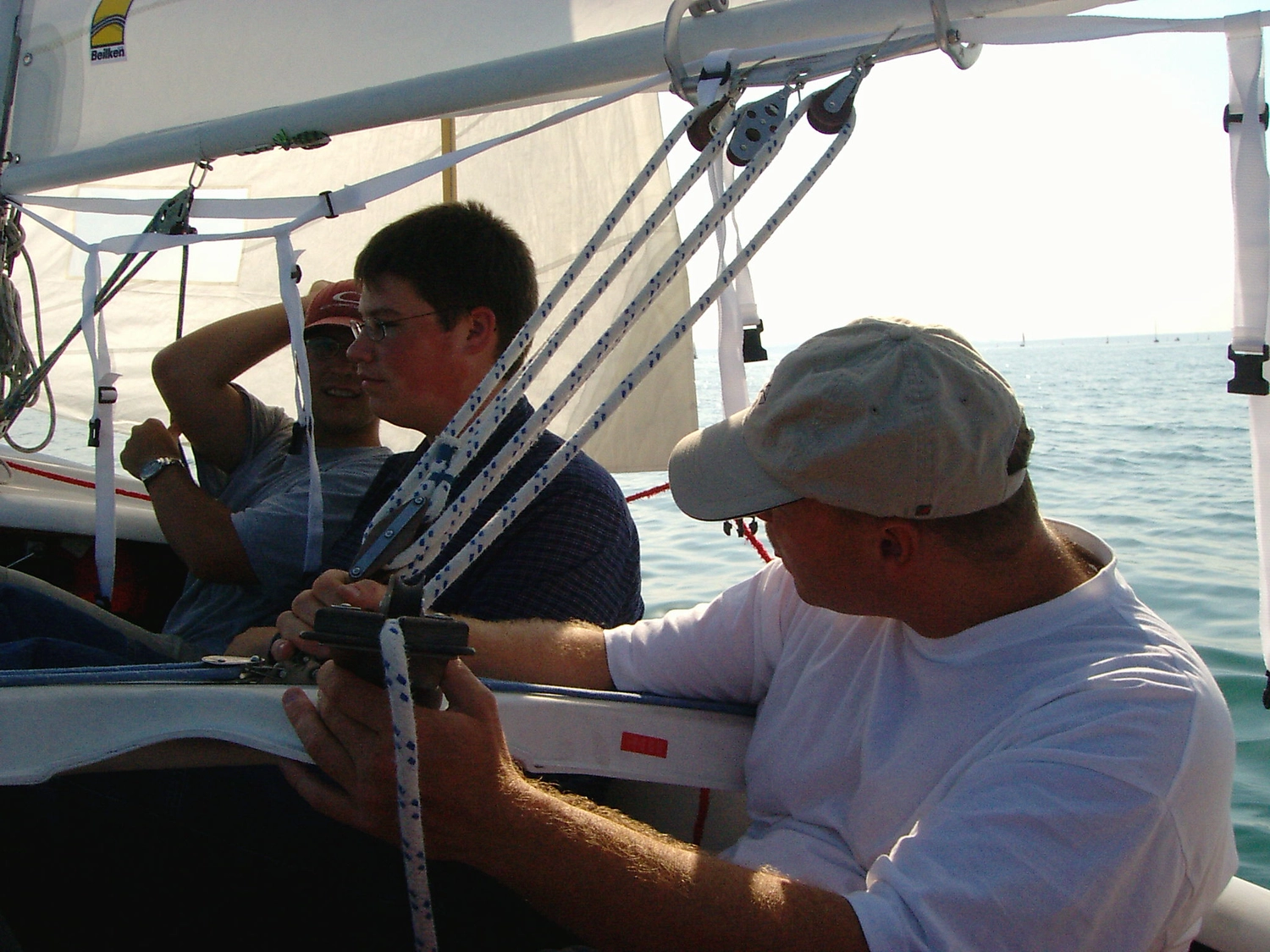 Motorboot-u. Segelschule Ravensburg - Wassersportausbildung und lizenzierung - Zwei Männer auf einem Segelboot, einer schaut durch ein Fernglas, der andere steuert.
