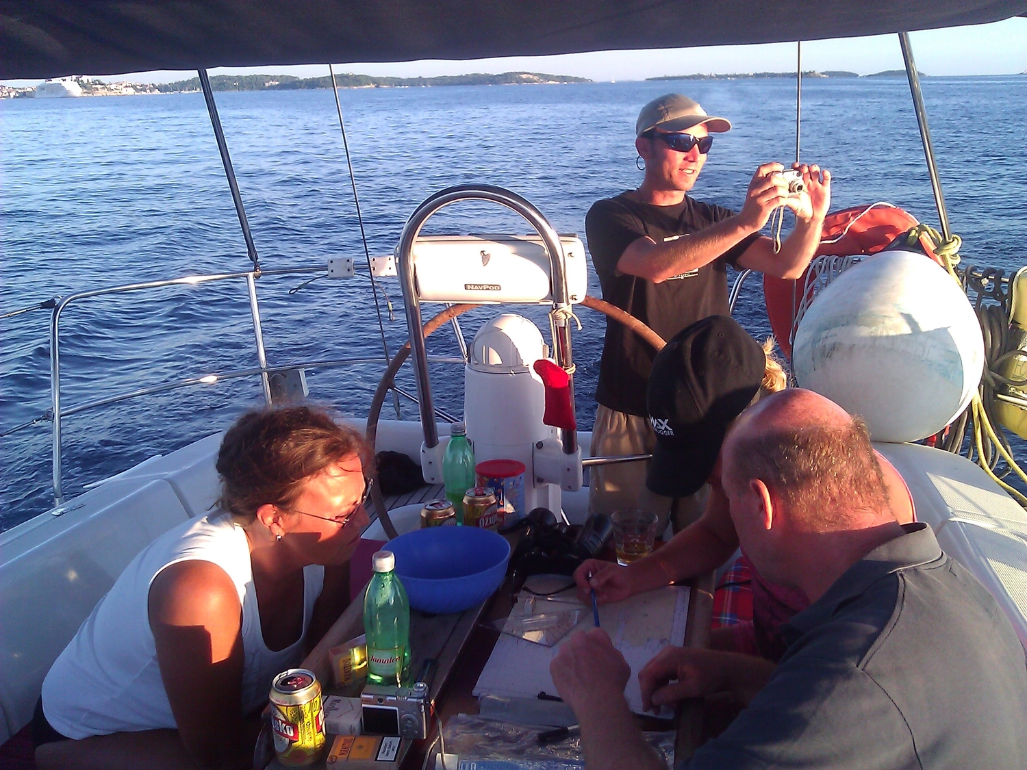 Motorboot-u. Segelschule Ravensburg - Wassersportausbildung und lizenzierung - Eine Gruppe von Menschen entspannt sich und unterhält sich an Deck eines Segelboots auf See.