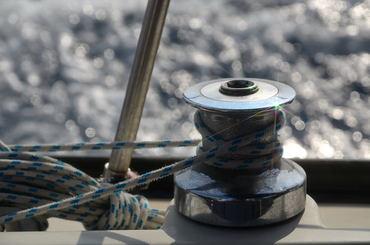 Motorboot-u. Segelschule Ravensburg - Wassersportausbildung und lizenzierung - Eine Nahaufnahme mit geringer Schärfentiefe zeigt eine Metallwinde und ein Seil auf einem Bootsdeck.
