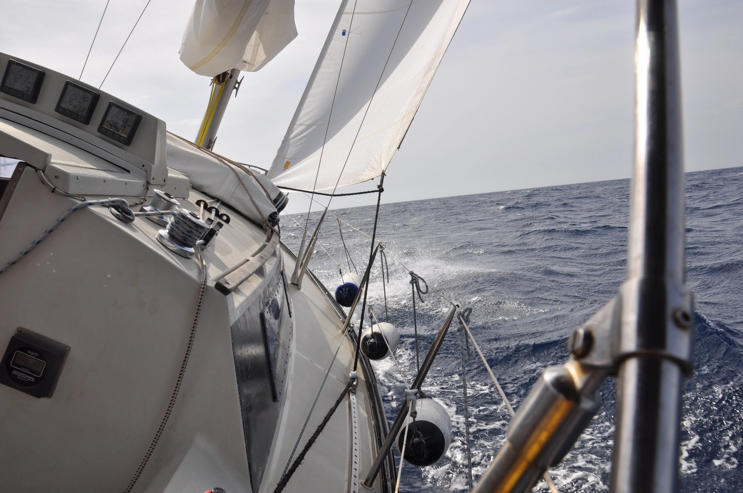 Motorboot-u. Segelschule Ravensburg - Wassersportausbildung und lizenzierung - Blick auf den Mast und die Takelage eines Segelboots, die sich beim Segeln durch die Wellen neigen.