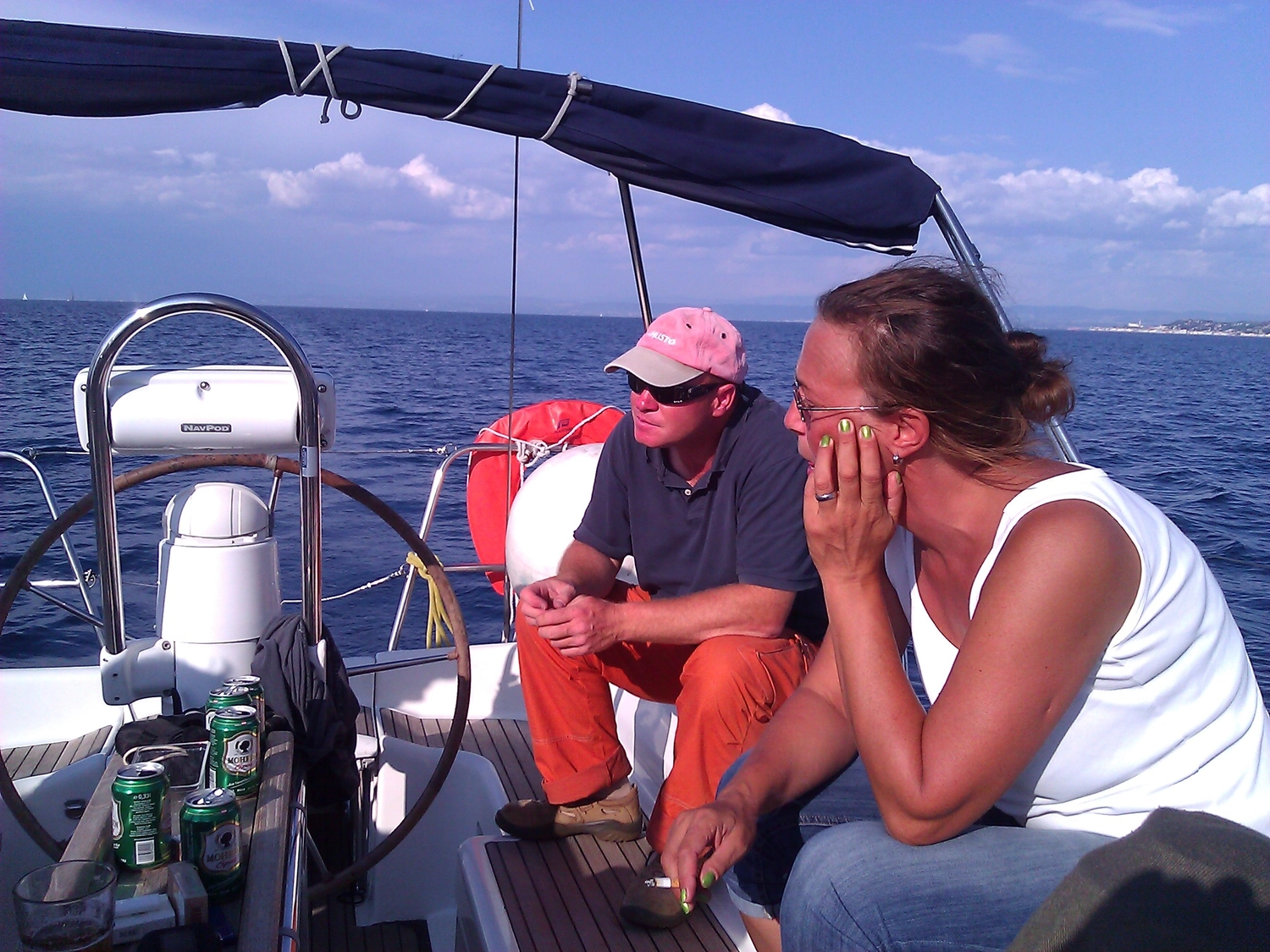 Motorboot-u. Segelschule Ravensburg - Wassersportausbildung und lizenzierung - Zwei Personen sitzen im Cockpit eines Segelboots in der Nähe des Steuerrads.