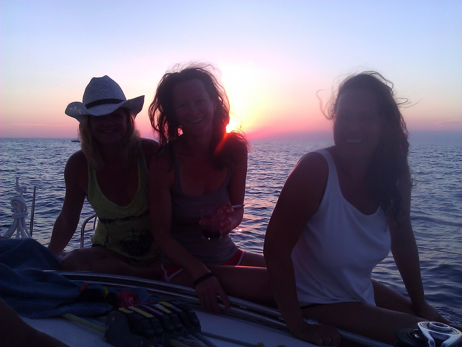 Motorboot-u. Segelschule Ravensburg - Wassersportausbildung und lizenzierung - Drei Personen sitzen bei Sonnenuntergang auf dem Deck eines Bootes.