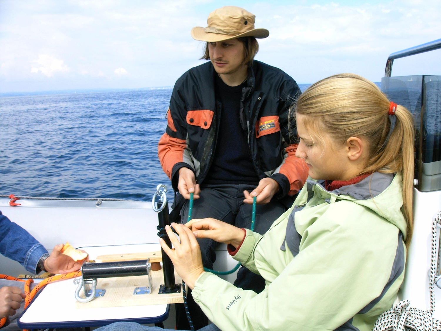 Motorboot-u. Segelschule Ravensburg - Wassersportausbildung und lizenzierung - Eine junge Frau lernt auf einem Boot das Knotenbinden, während ein Ausbilder zusieht.