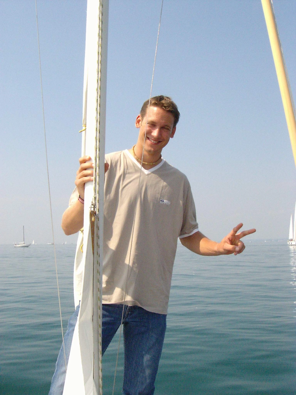 Motorboot-u. Segelschule Ravensburg - Wassersportausbildung und lizenzierung - Ein Mann steht unter klarem Himmel auf dem Deck eines Bootes.