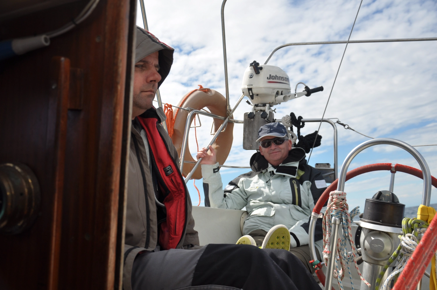 Motorboot-u. Segelschule Ravensburg - Wassersportausbildung und lizenzierung - Zwei Personen ruhen sich im Cockpit eines Segelboots aus und navigieren.