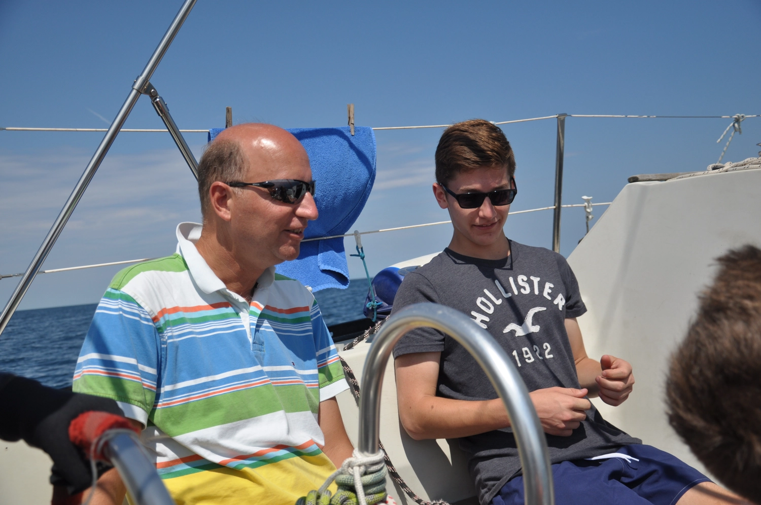 Motorboot-u. Segelschule Ravensburg - Wassersportausbildung und lizenzierung - Zwei Männer am Steuer, einer in einem gestreiften Polohemd, der andere in einem grauen T-Shirt.